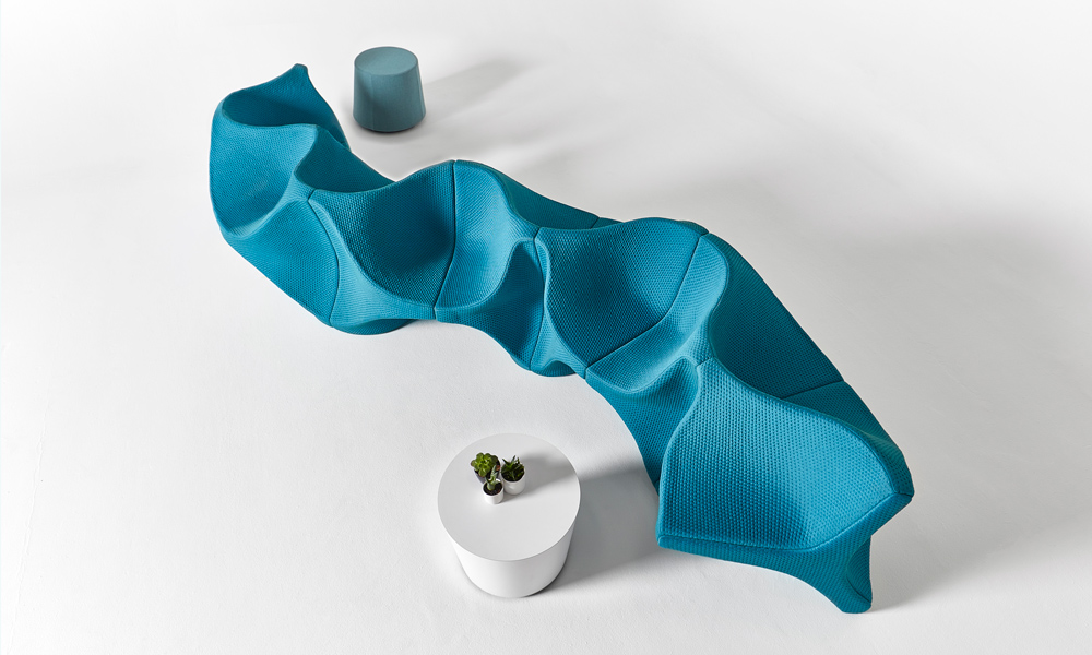 overhead view of sinuous aqua upholstered lounge seating in white room