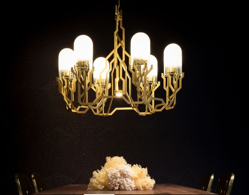 gold geometric chandelier with glass dome shades against black background in dark dining room