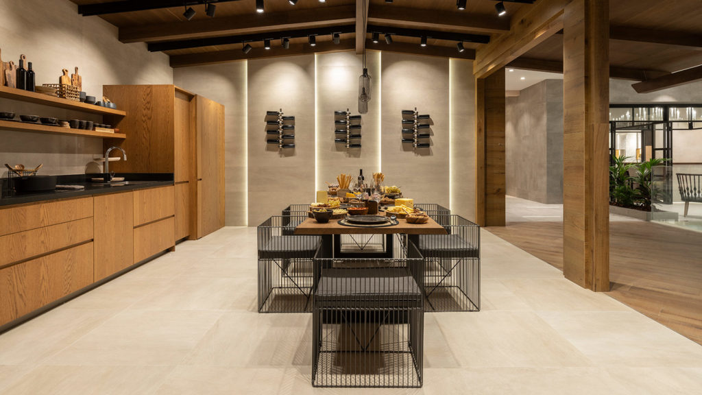modern earth-tone kitchen with vaulted wood ceiling, modern dining table, and beige floor and wall tiles