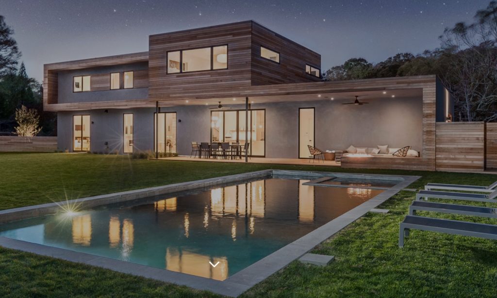 Modern Net Zero Hamptons' home exterior image with horizontal wood siding and pool in foreground 