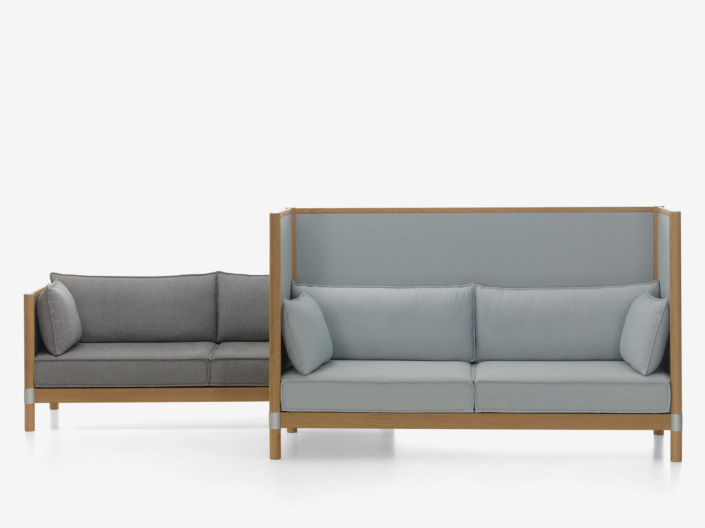 two Vitra Cyl sofas, one with high back panel, both in gray upholstery and medium-toned wood 