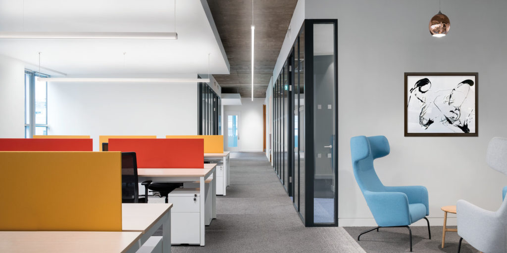 Fluxwerx LED Luminaires three Profile Mini lights in office hallway with yellow and orange desk partitions and blue chair 
