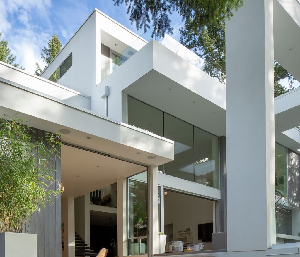 AFT House exterior shot of contemporary home with large white pillars and floor to ceiling windows
