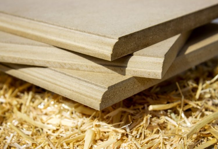 CalPlant Rice-Straw MDF close-up of MDF sheets with bullnose edge atop a pile of rice straw