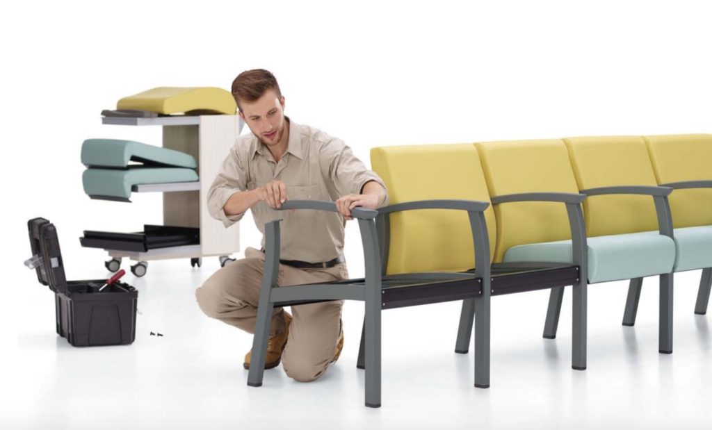 Primacare Seating male technician servicing chairs and assembling arm cap teal seat with yellow upholstery