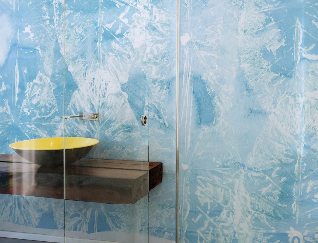 WallPepper's Special Systems blue background with white translucent butterflies in bathroom with black and yellow washbasin