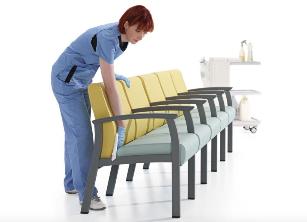 Primacare Seating ganged chairs yellow and teal with woman cleaning chair