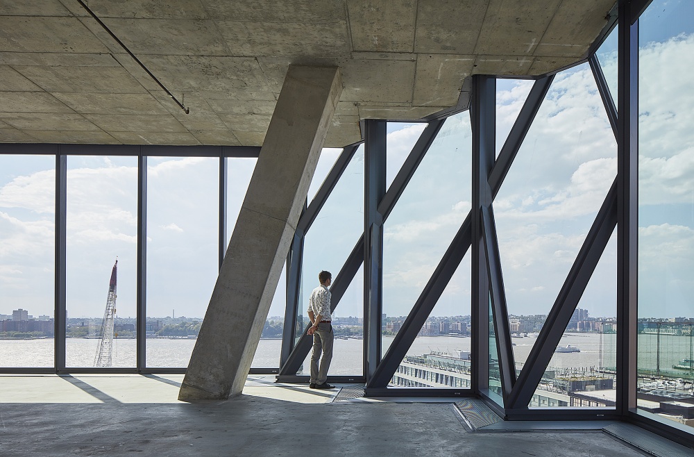 Studio Gang Solar Carve interior image with man looking out of faceted curtain wall