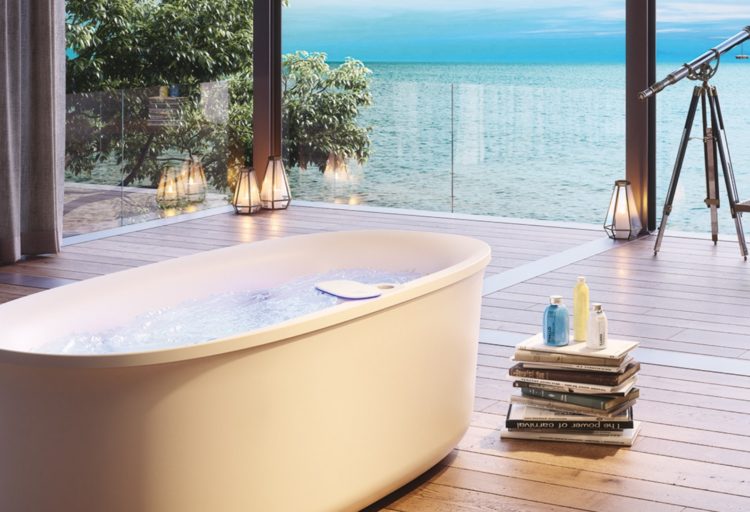 Jacuzzi's Arga bathtub in nice bathroom with wood floor with pile of books nearby and telescope with ocean view