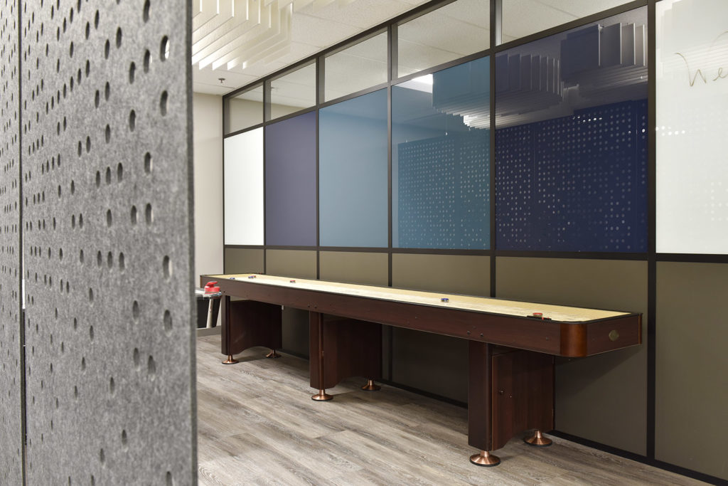 ezoBord's Work Zone Dividers Pixelated Circles in gray, blue, purple, and white in hallway with tabletop shuffleboard game