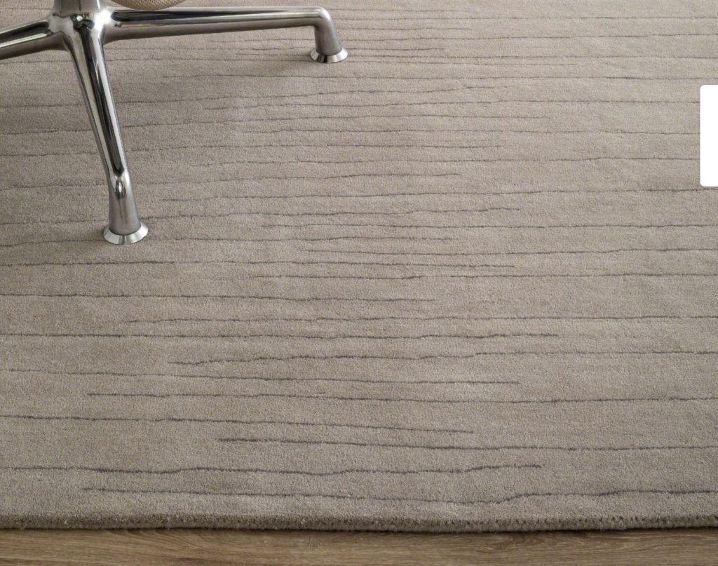 Nanimarquina Collection for Coalesse Strokes style close-up of thin random black lines on gray rug with chrome chair base 