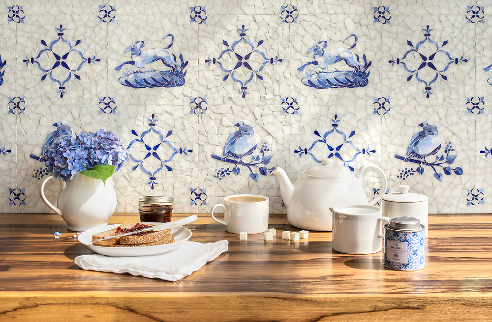 Blue Sea Glass Collection Delft Style with birds and lambs against a white background very pastoral behind kitchen table