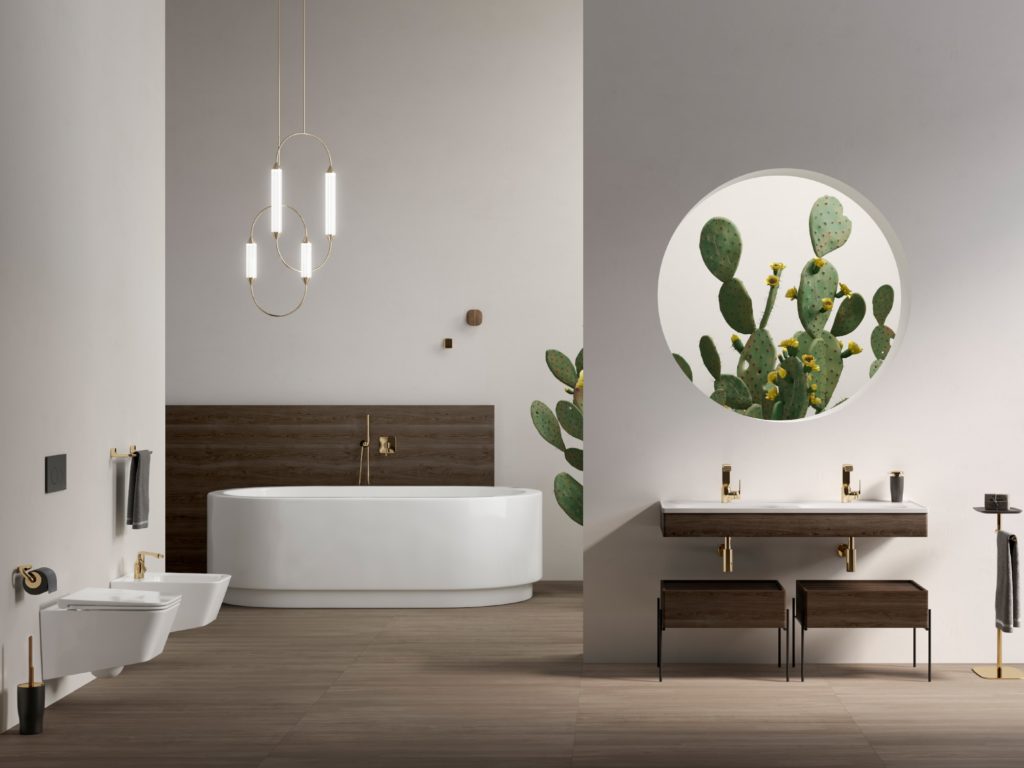 Claudio Bellini Equal Bathroom with toilet, bidet, bathtub, and vanity all white in open bathroom with a large cactus and circular window