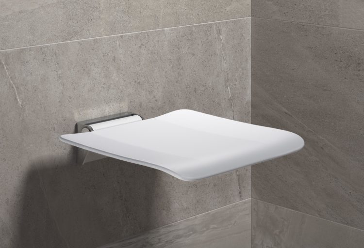 Hewi System 900 fold-down shower seat in white against gray tile