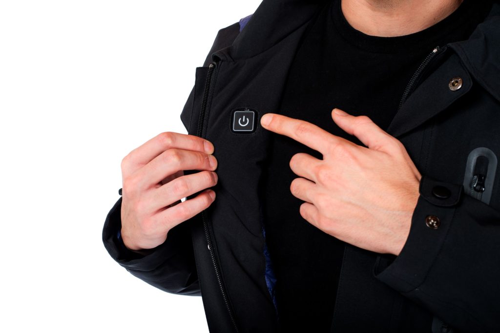 Ultra Coat model holding coat open while wearing it to show heat-activation button 
