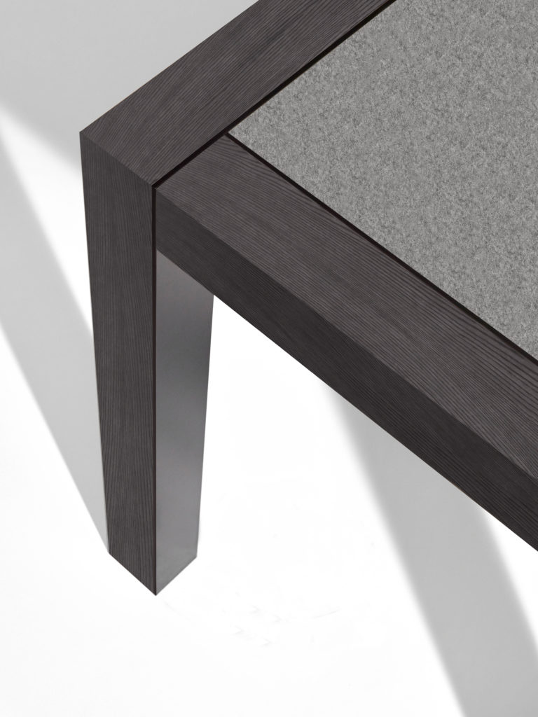 Nucraft's Epono Table top detail with concrete top and black wood veneer frame and legs


