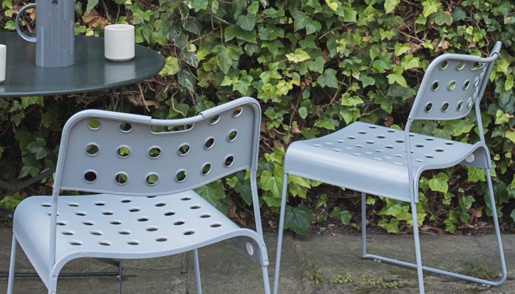 Sandler Stak Chair two gray chairs outdoors with Ivy wall