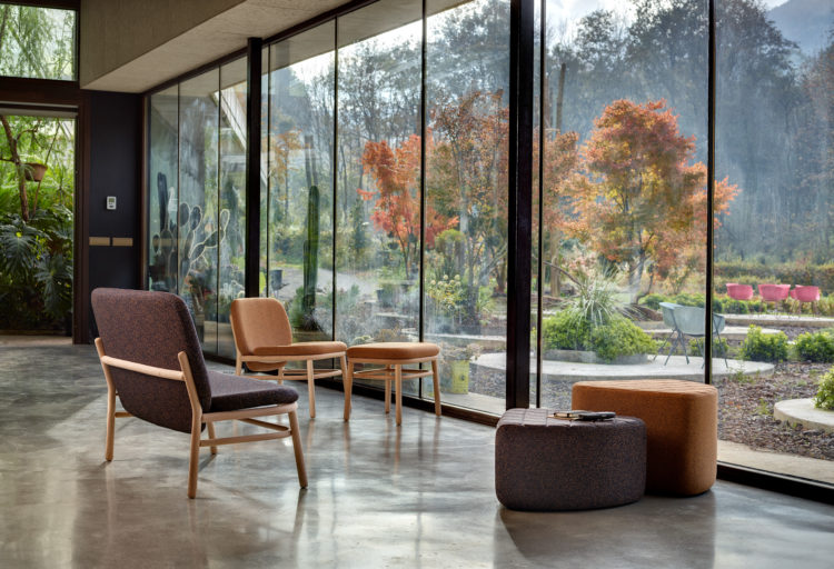 Hightower's Lana Seating sofa, chair, and poufs in front of window with nature view