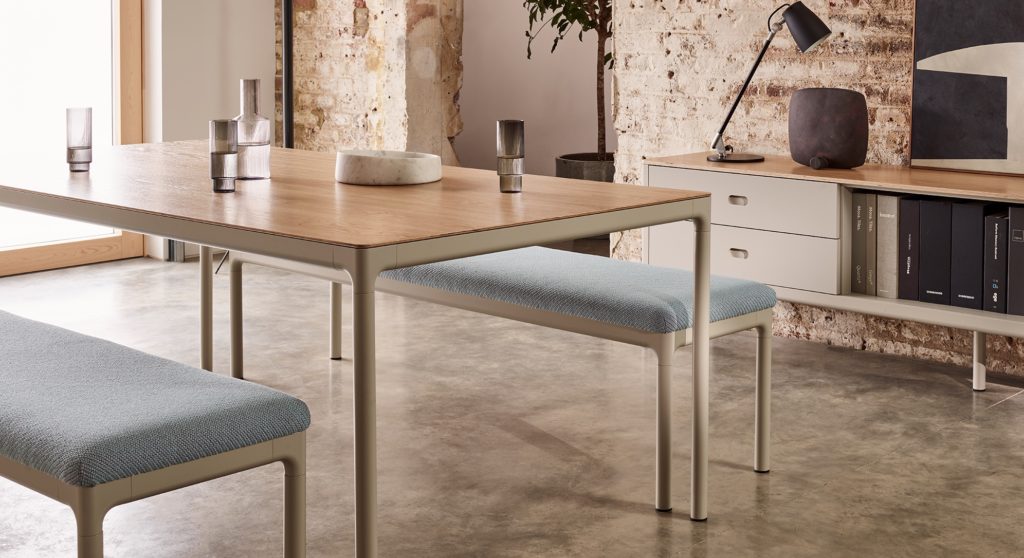 Pearson Lloyd Edge Collection desk with wood laminate top and benches with light blue upholstery