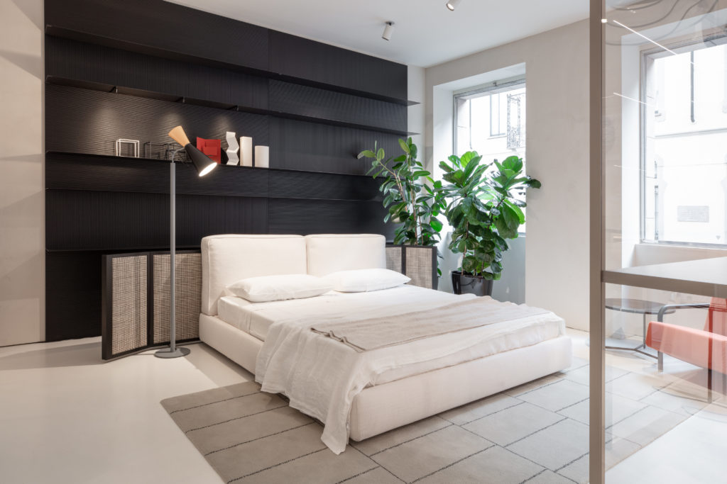 Electric Box bedroom with black wood shelving and white bed