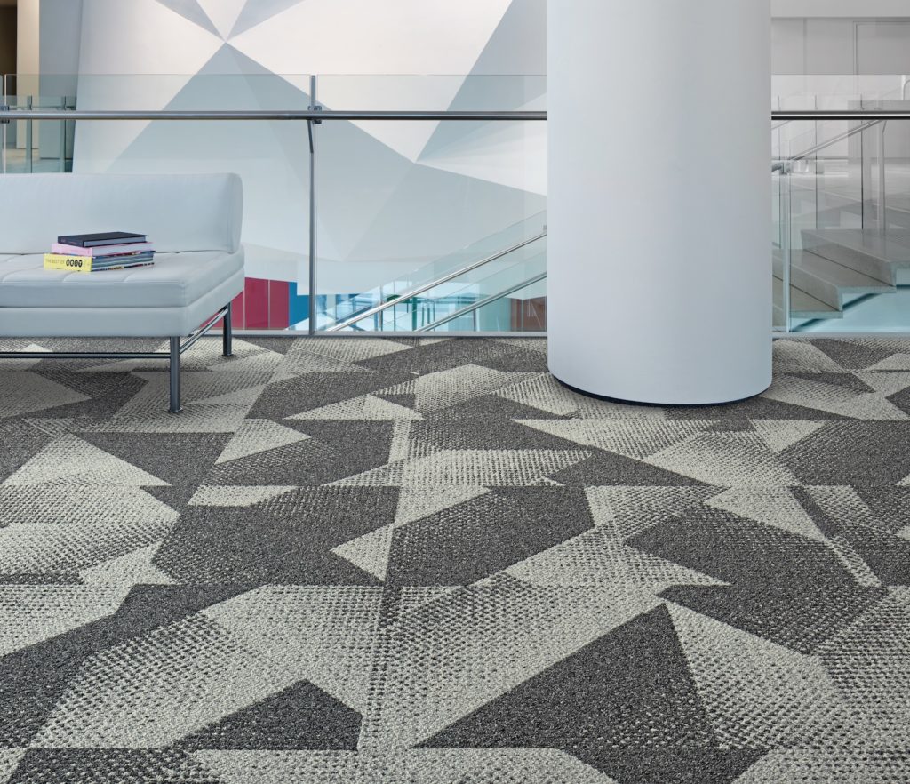 Rising Signs Carpet Tiles Upward Bound light and dark trapezoids and triangles with small circles throughout in atrium