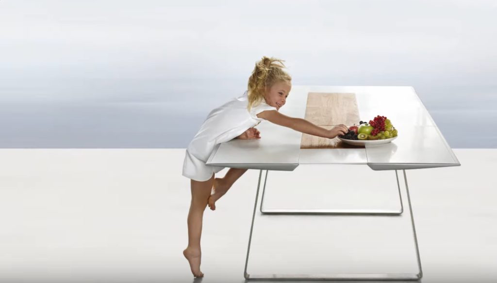 Extrados table with girl reaching for plate of fruit