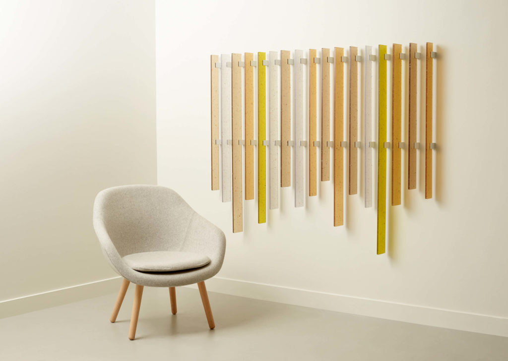 3form flek pure clear, peach, orange, and yellow in decorative strips on wall with chair