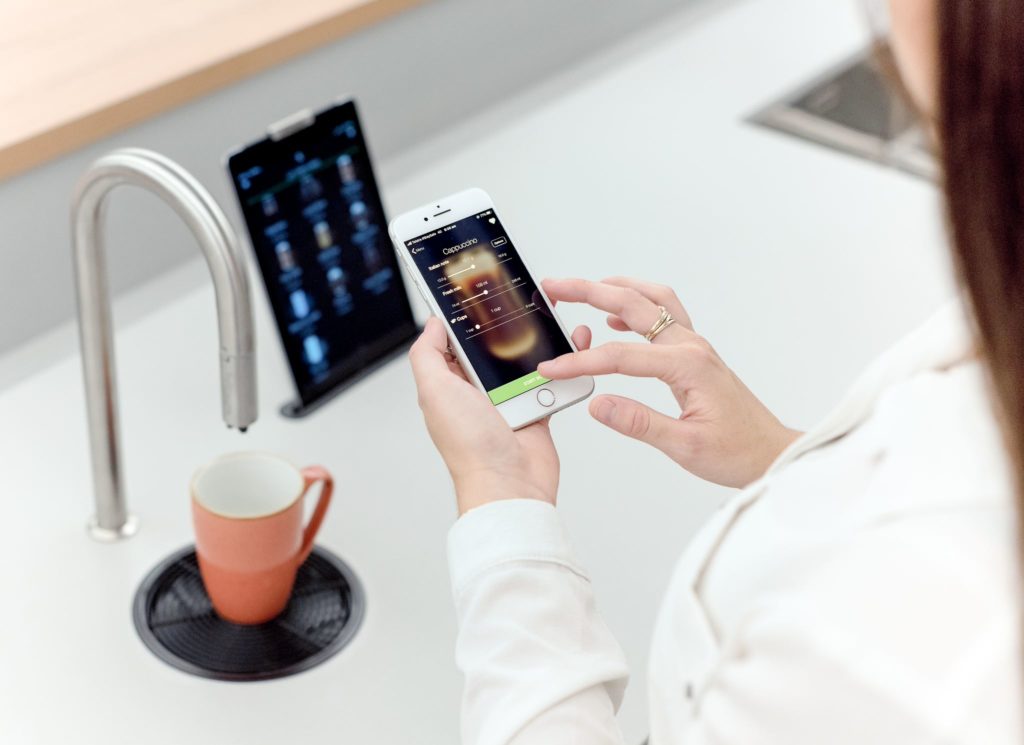TopBrewer woman using phone to create coffee drink 
