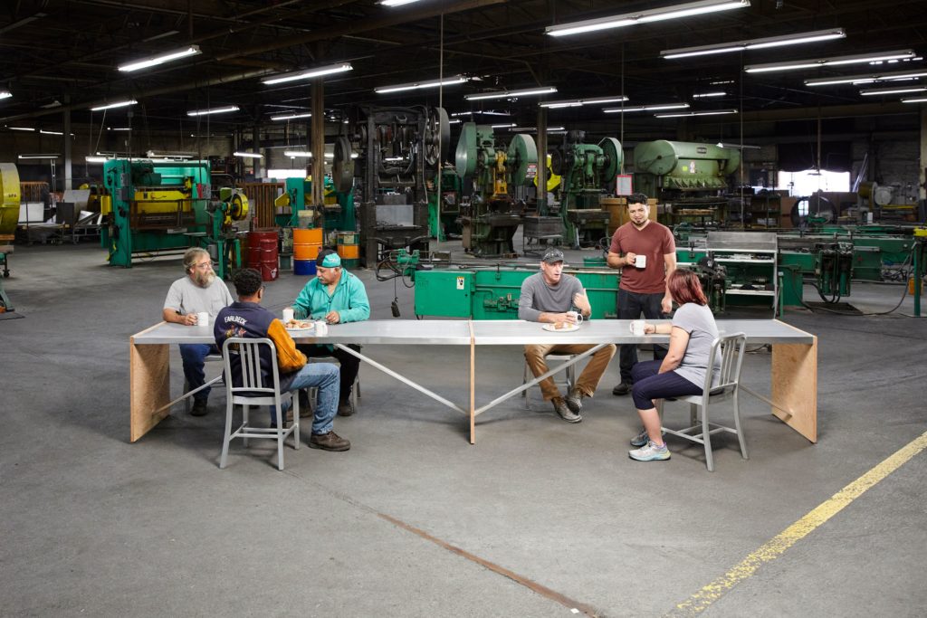 Truss table for Emeco with workers having coffee and donuts