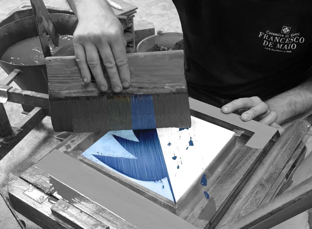 Blu Ponti artisan brushing glaze onto tile in production