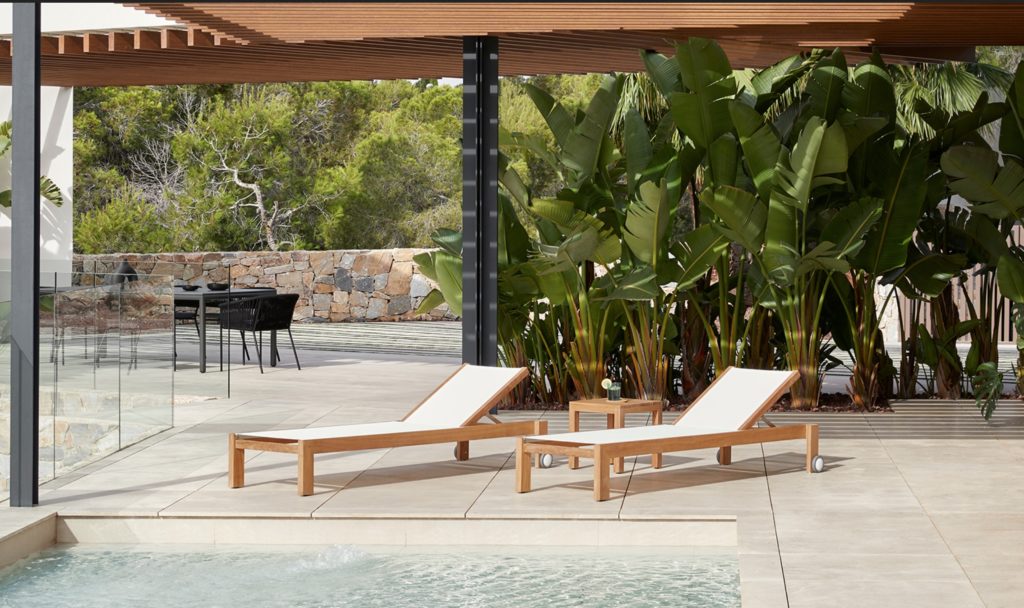 Bay Collection loungers poolside with lots of greenery surrounding 