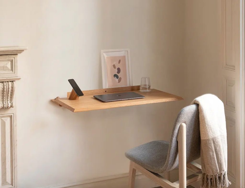 Alada desk in natural with phone and tablet on it near chair with a blanket draped over it