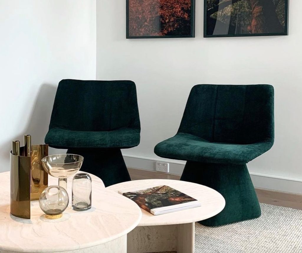 two lounge chairs with pedestal bases in green velvet