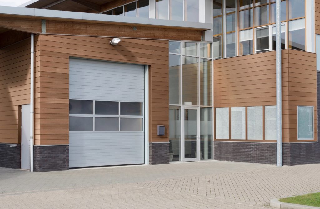 Exterior of fire department with medium-toned wood cladding on garage and first floor