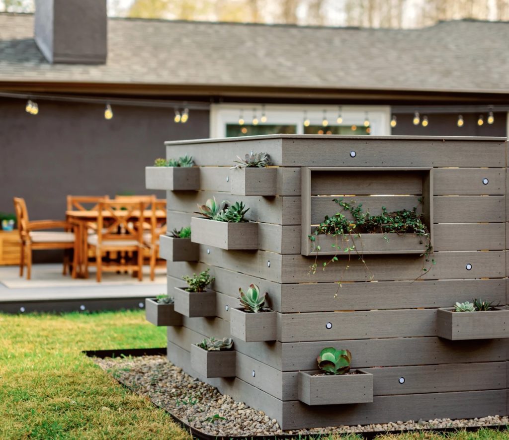 Medium-gray planter made of composite cladding with little compartments for succulent plants