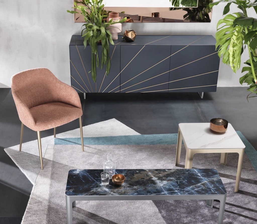 Riflessi Corner collection  with bureau coffee table with blue marble top and side table with white marble top next to salmon colored chair