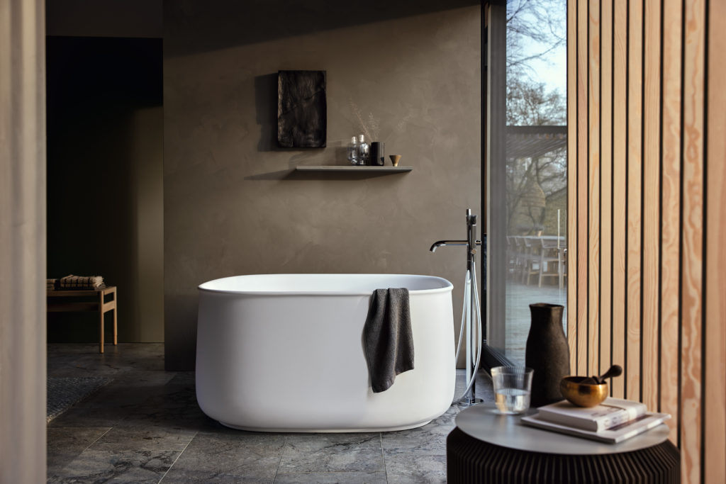 Zencha line spacious and deep bathtub with standing tub filler in bathroom with slatted wood curtains