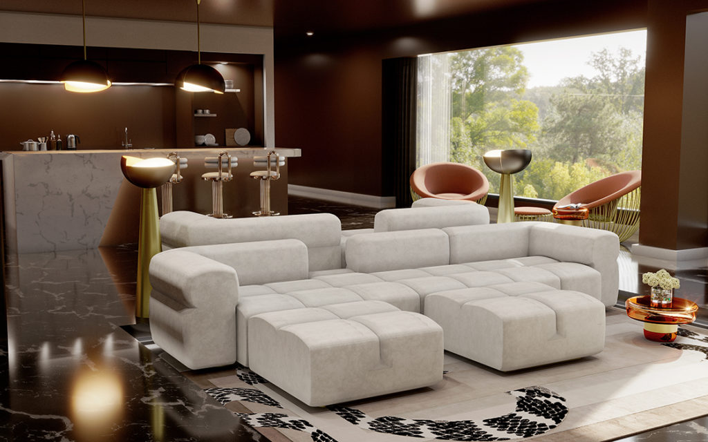 A large white sectional sofa in a room with a white rug, dark wood floors, and bar with golden bar stools