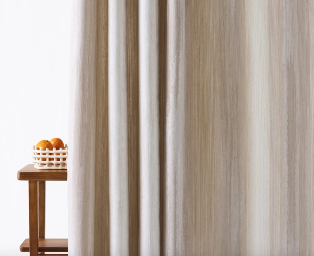 Privacy curtains in gray/beige with subtle line pattern near basket of oranges