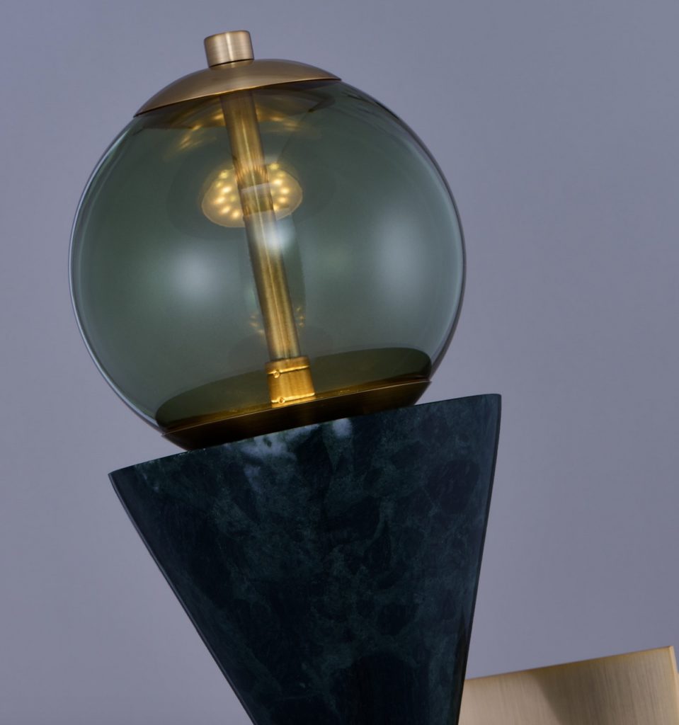 A small pendant lamp with a smoky green shade and pillar shaped golden filament