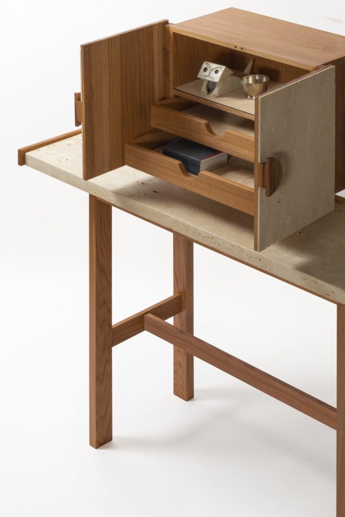 A console made of a walnut frame and Travertine top with a small cabinet on top with marble doors open to reveal three small drawers