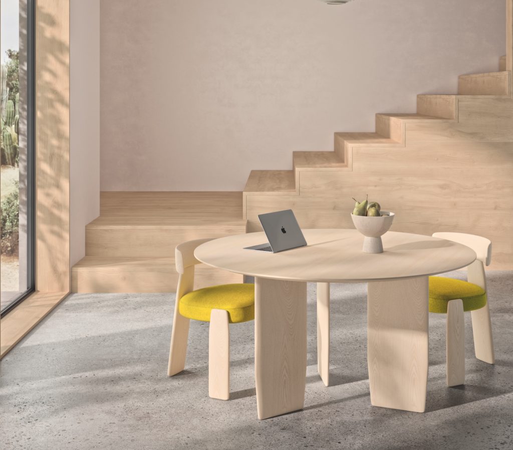 A room with a wooden staircase and Oru table with Oru chairs with yellow upholstered seats
