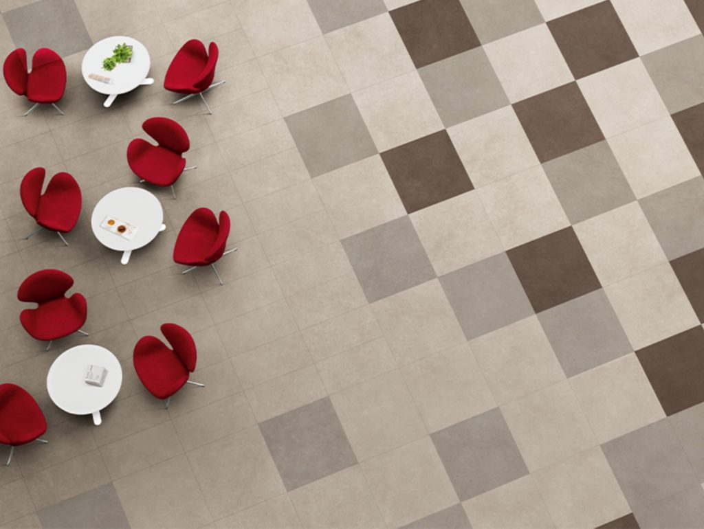 Plaster 2.0 view from above of large format tiles on floor in light gray, gray, and espresso with red chairs