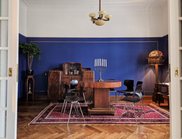 Kaunas apartment building interior with blue wall, decorative rug, and spare modern furniture