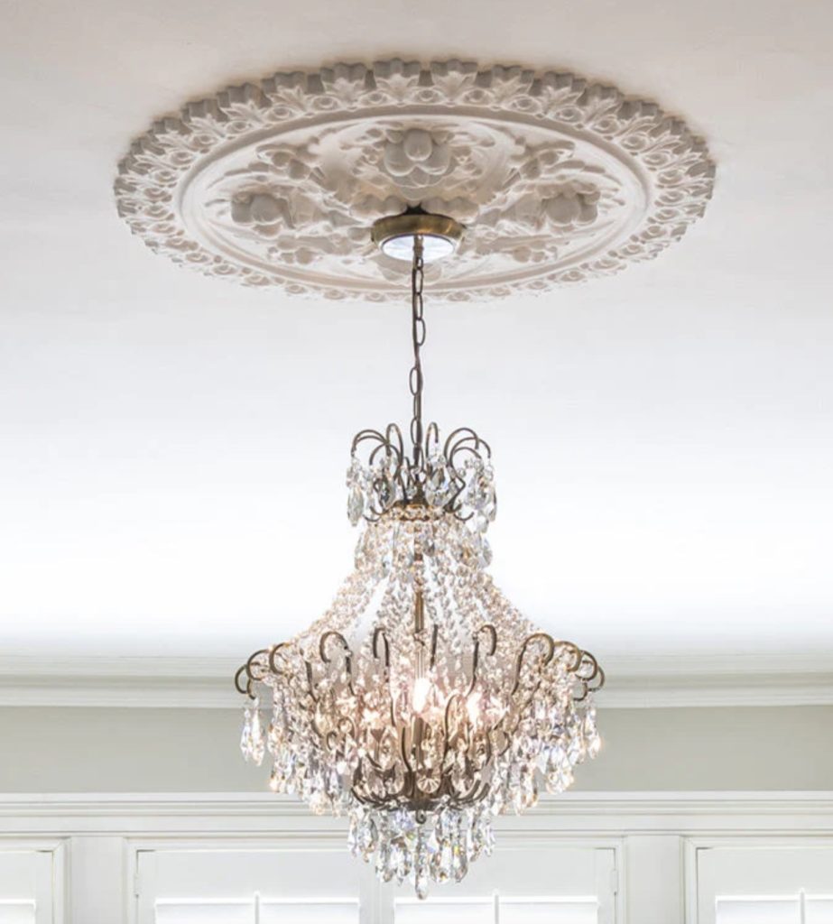 Lina chandelier from Lights&Lamps with very ornate glass beads and brass and intricate molding at ceiling
