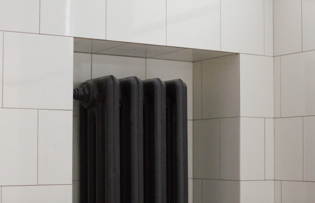 Iron radiator in tiled nook