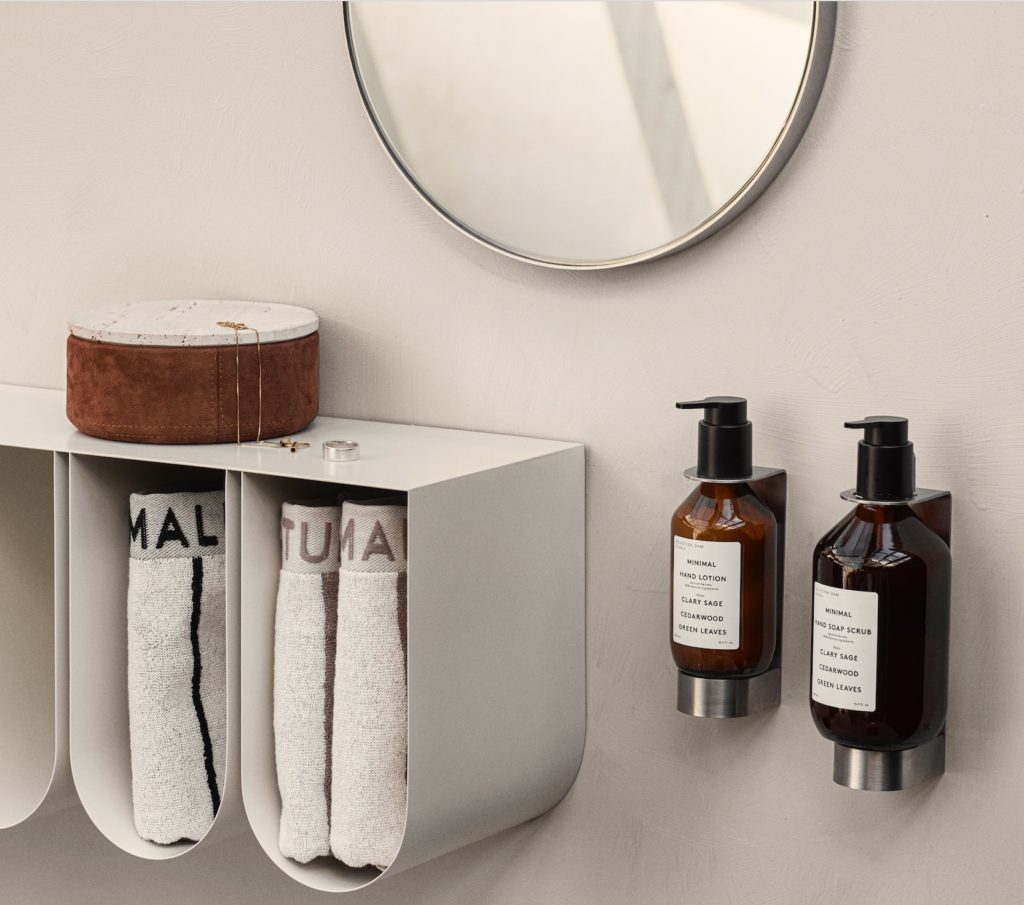 Curved wall shelf in white partial view in bathroom with towels in compartments