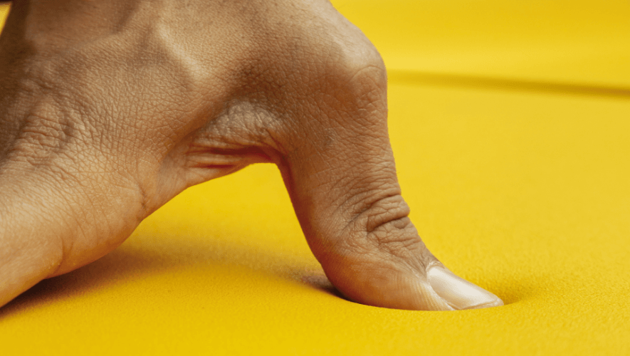 Bõln detail of Flexyskin in yellow with thumb demonstrating pliability