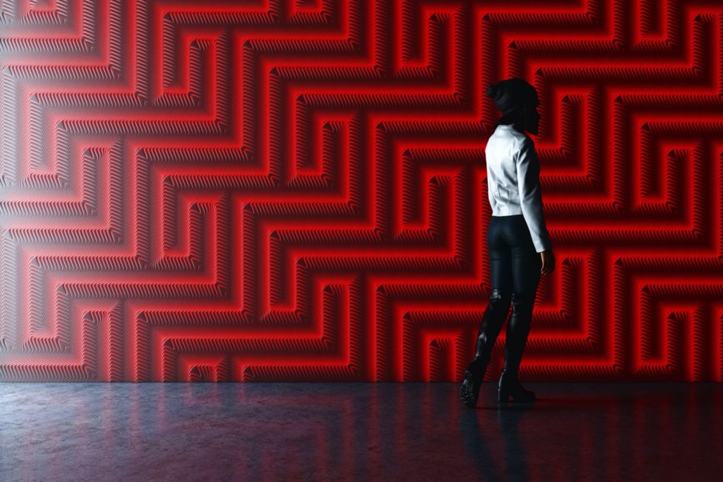 Patternine solid surface with a maze-like aspect in backlit red light with woman looking on