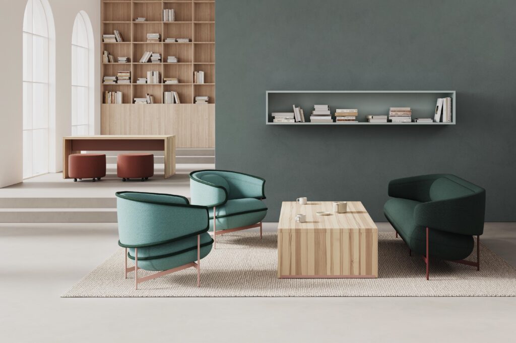 Flote lounge in blue/green with black seams; Flote sofa in forest green in workplace setting with wood coffee table, small bookshelf, and large area rug